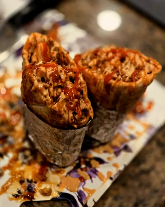 Bussdown Designer Burrito cut open showing steak, sauce and garlic noodles
